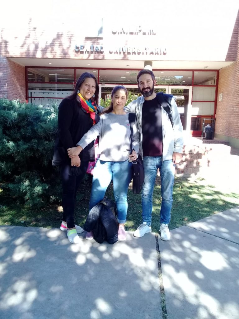 Tres estudiantes en la entrada del centro universitario